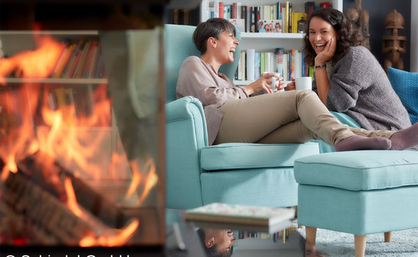 Zwei Frauen sitzen auf einer Couch neben dem Kamin